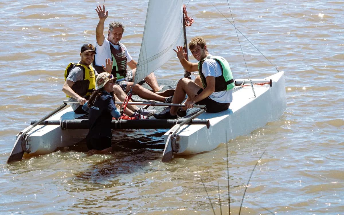 Un grupo saluda a bordo de un catamarán en el río