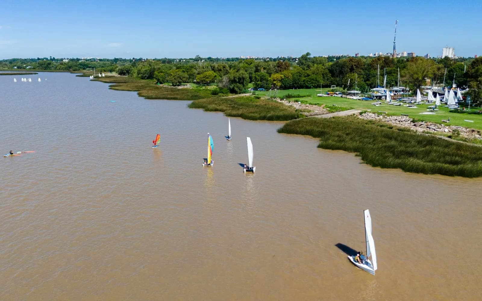 Vista aérea del Club de Veleros San Isidro, con veleros y windsurfistas en el río